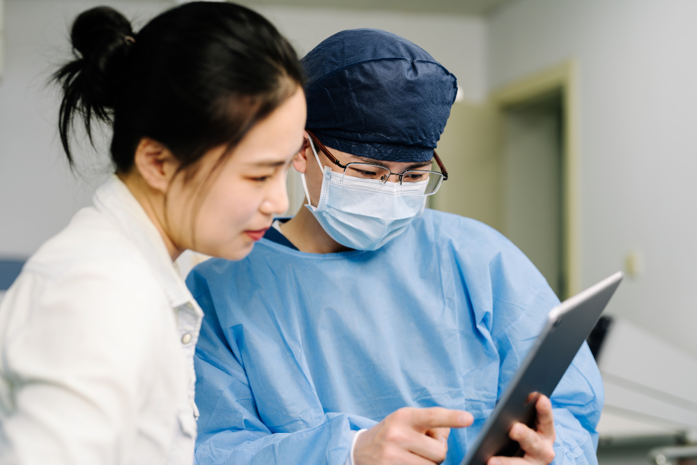 asian female surgeon showing asian woman something on tablet