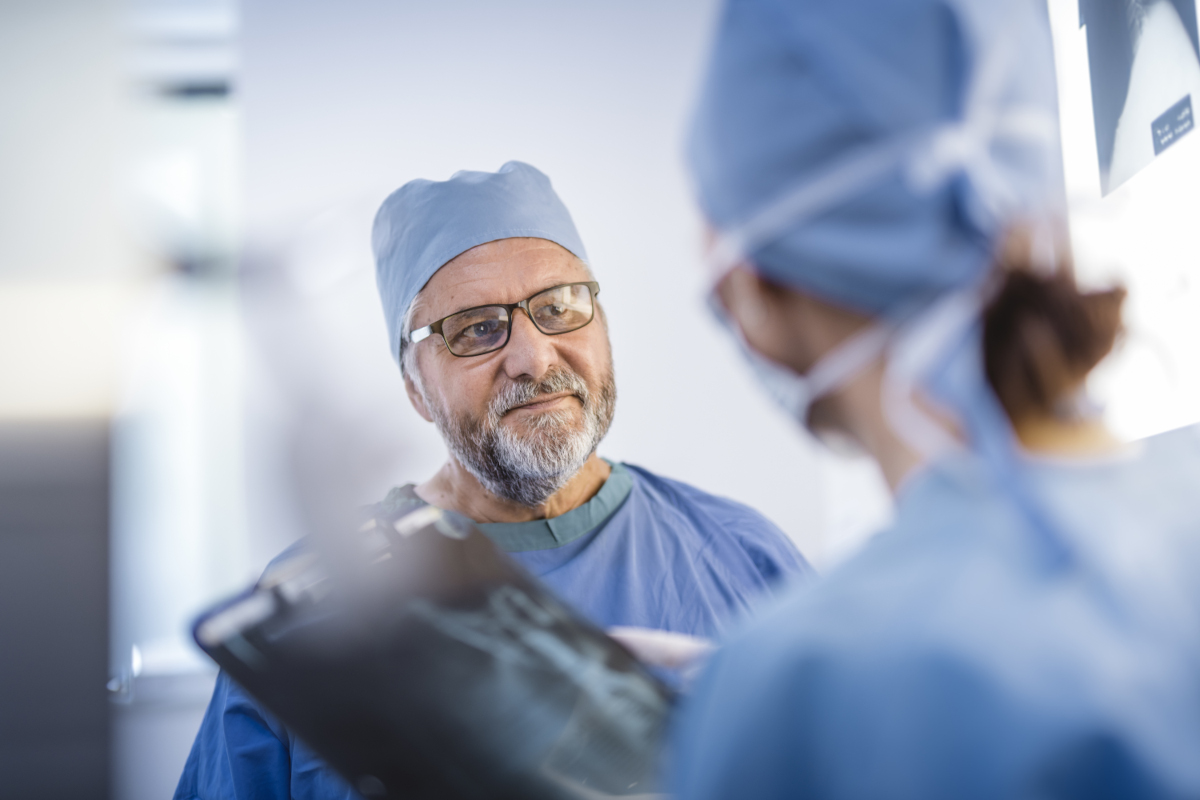 male surgeon looking at screen and listening to female surgeon