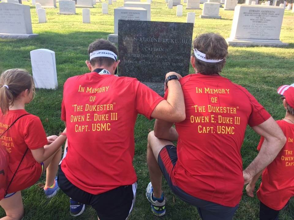 4 people kneeling at a grave