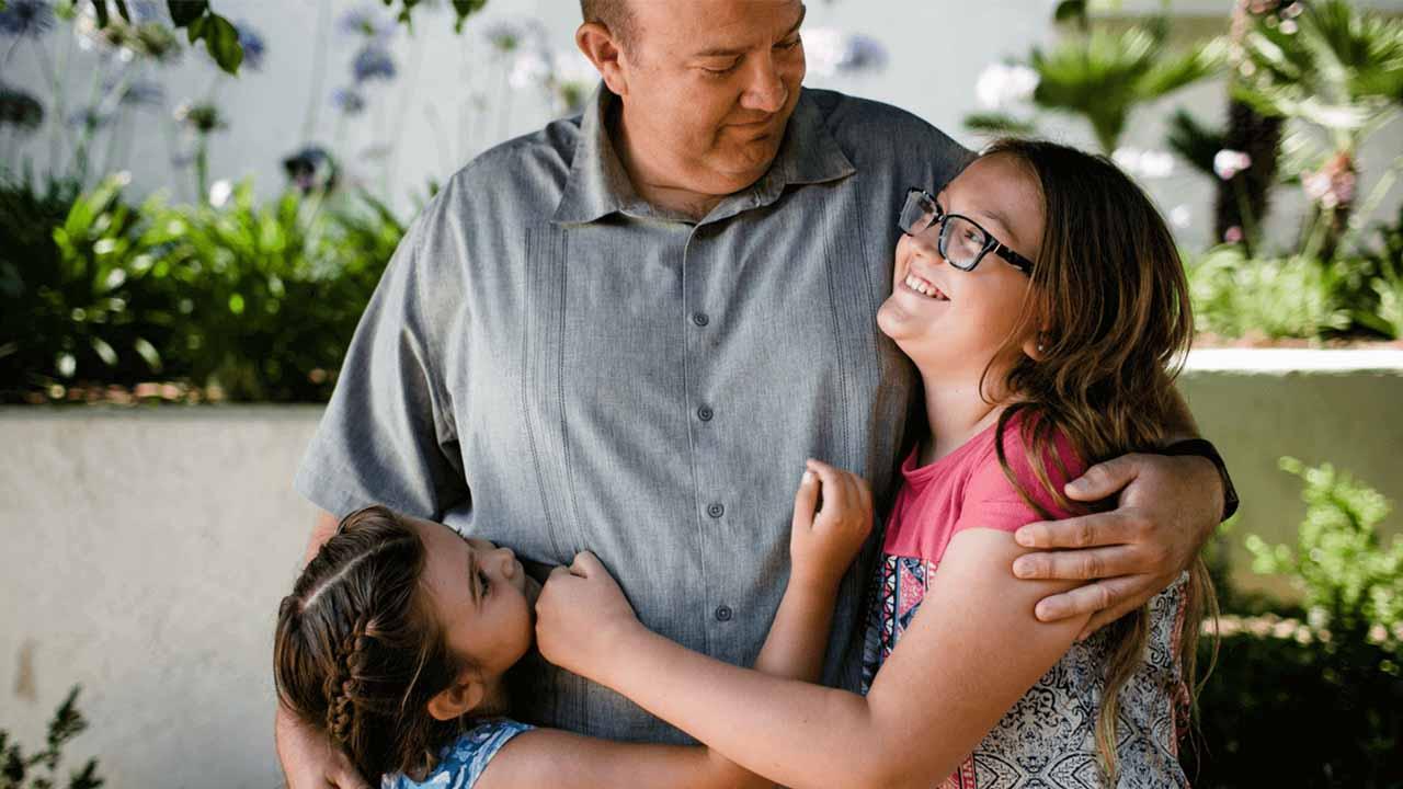 Overweight middle aged man hugging his two  children