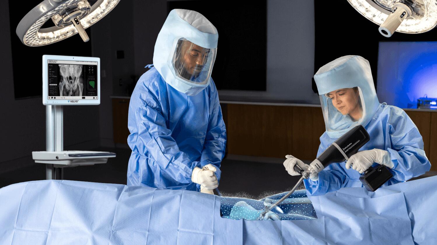 Surgeon in OR holding KINCISE 2 for cup extraction