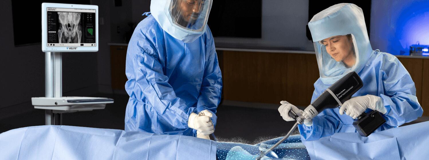 Surgeon in OR holding KINCISE 2 for cup extraction