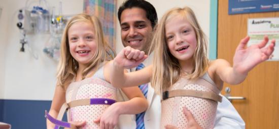 2 orthopaedic children with a doctor wearing spinal corrective medical devices